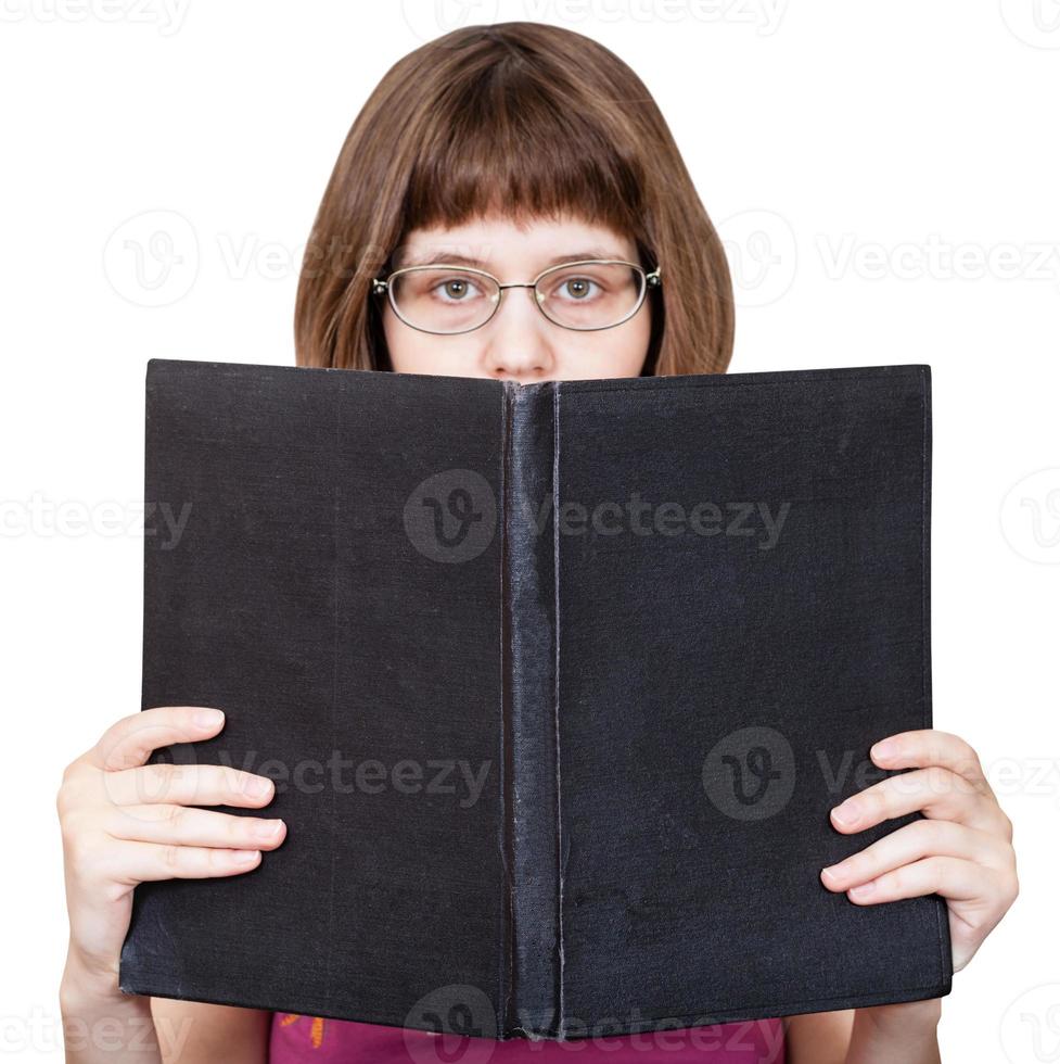 girl with glasses looks over big book isolated photo