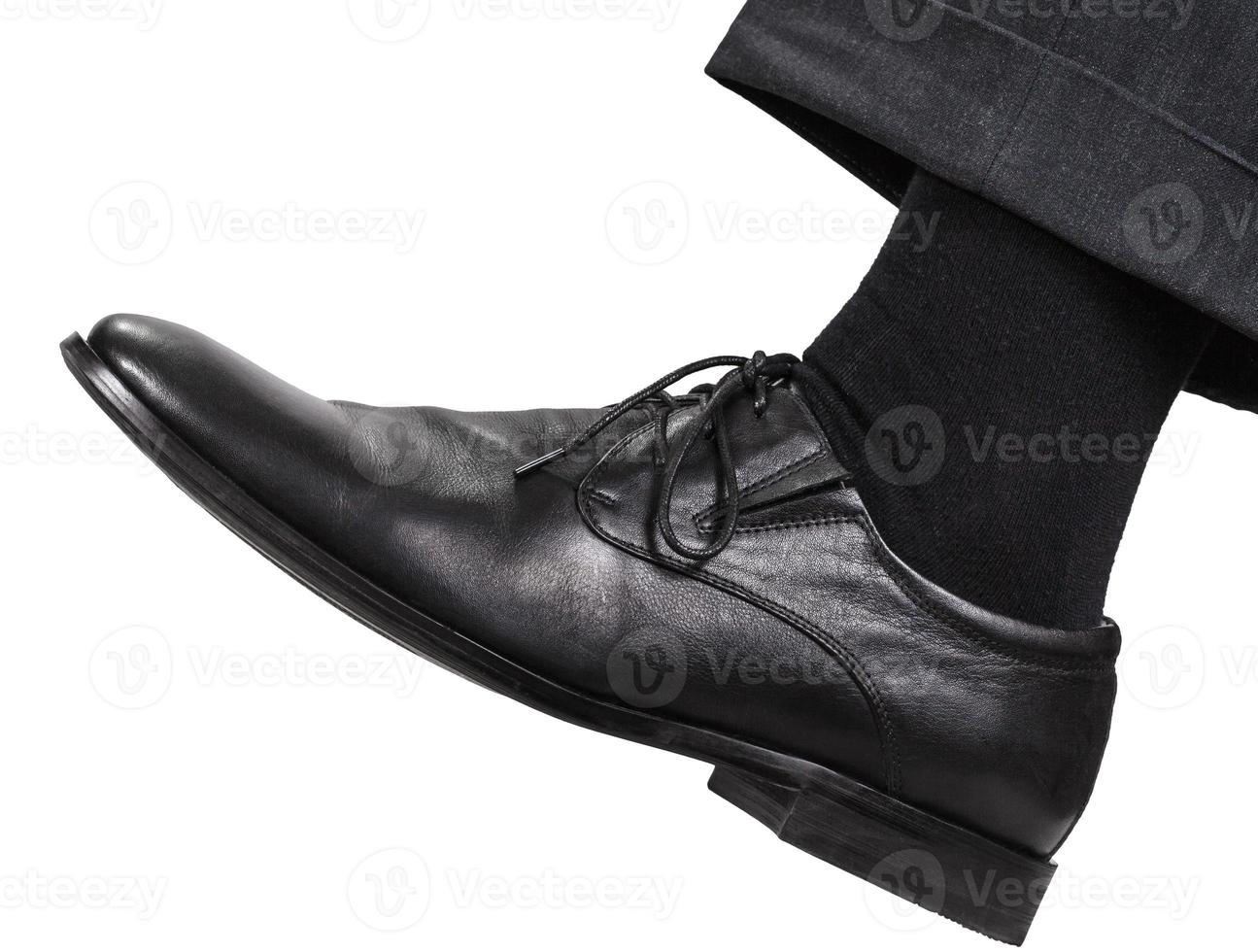 male left leg in black shoe takes a step photo