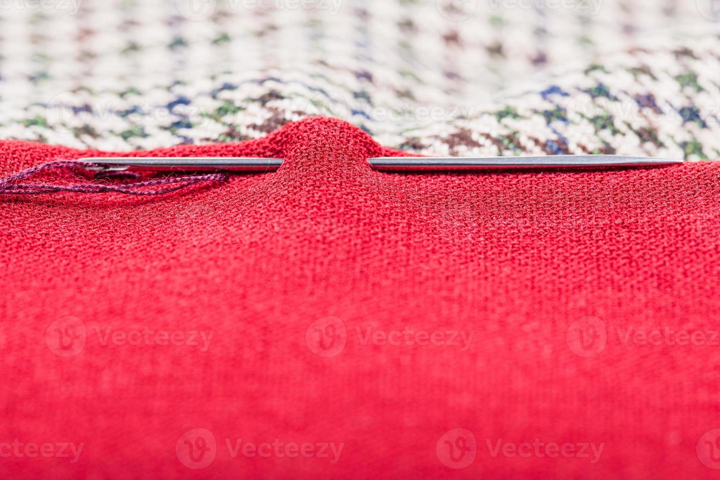 needle sews two pieces of cloth photo