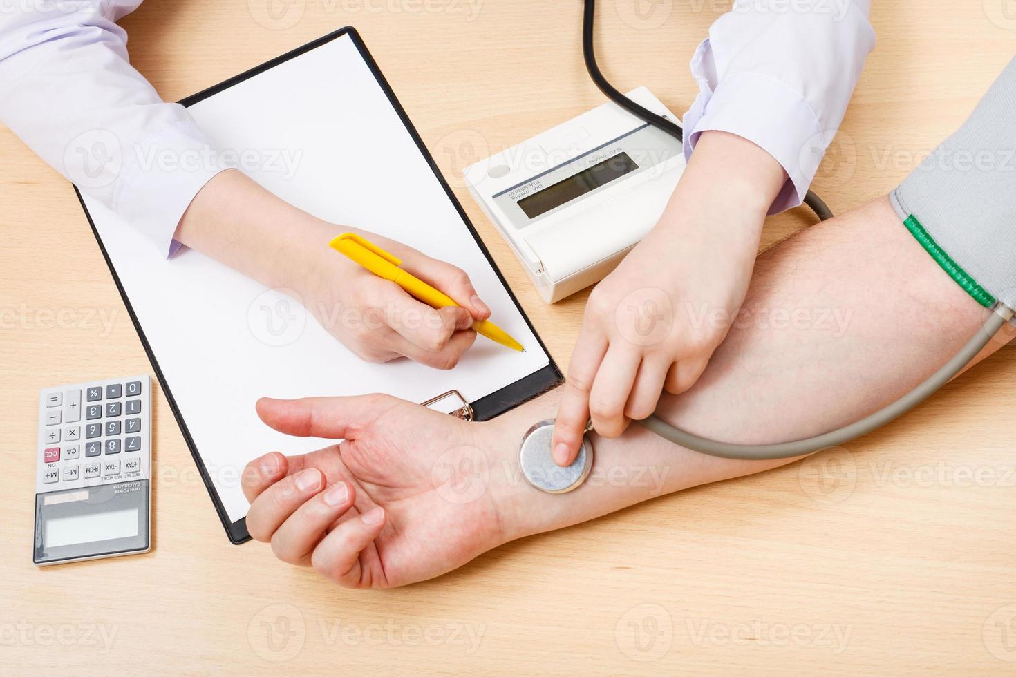 physician measures blood pulse of patient photo