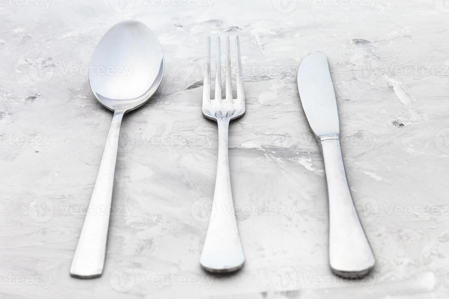 serving set from knife, fork, spoon on concrete photo
