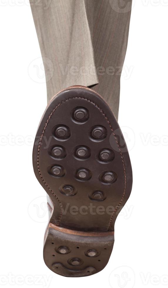 front view of male foot in brown shoe steps photo