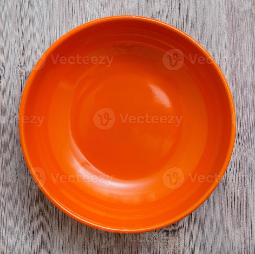 top view of orange bowl on gray brown table photo
