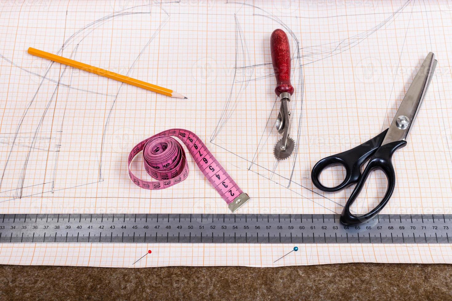 tissue, pen, pattern, tailor tool on cutting table photo