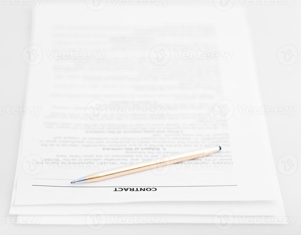 tres páginas de contrato de venta y bolígrafo dorado foto