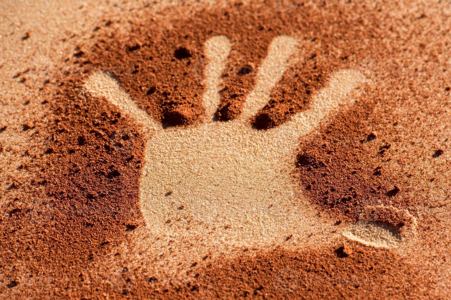 Red soil hand shape on sand like aboriginal art style photo