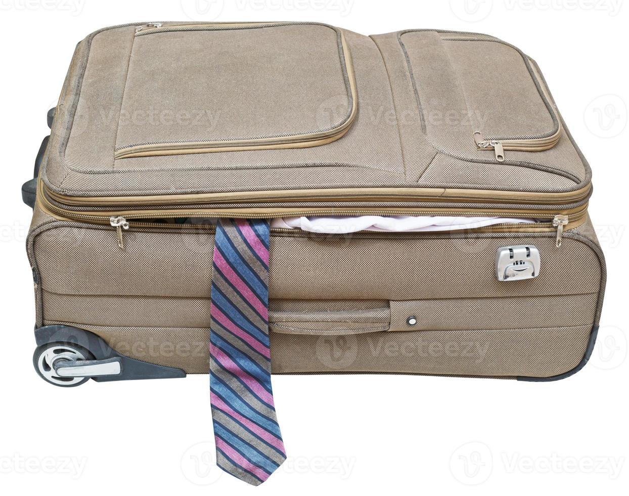 textile suitcase with fell out tie isolated photo