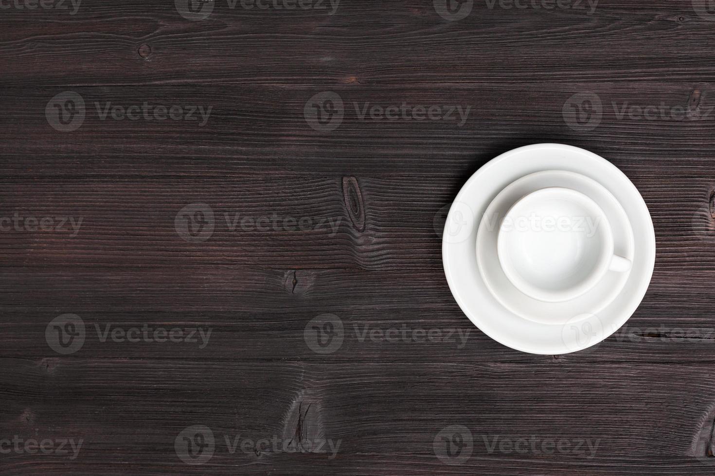 above view of cup with saucers on dark brown table photo