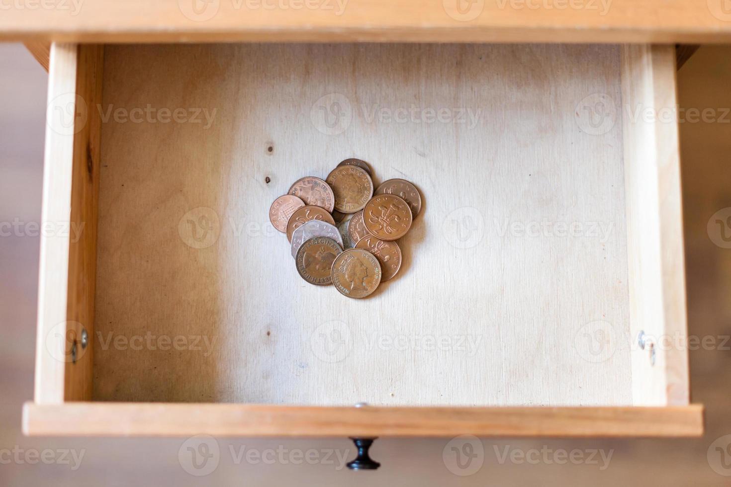 pile of british coins in open drawer photo