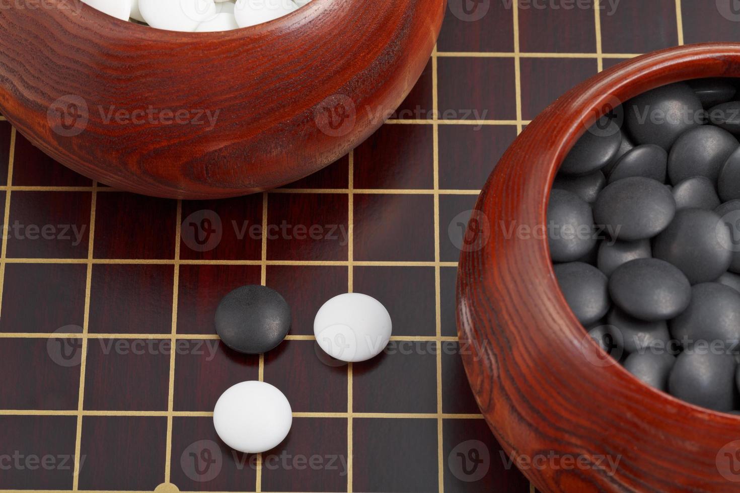 black and white go game stones and wooden bowls photo