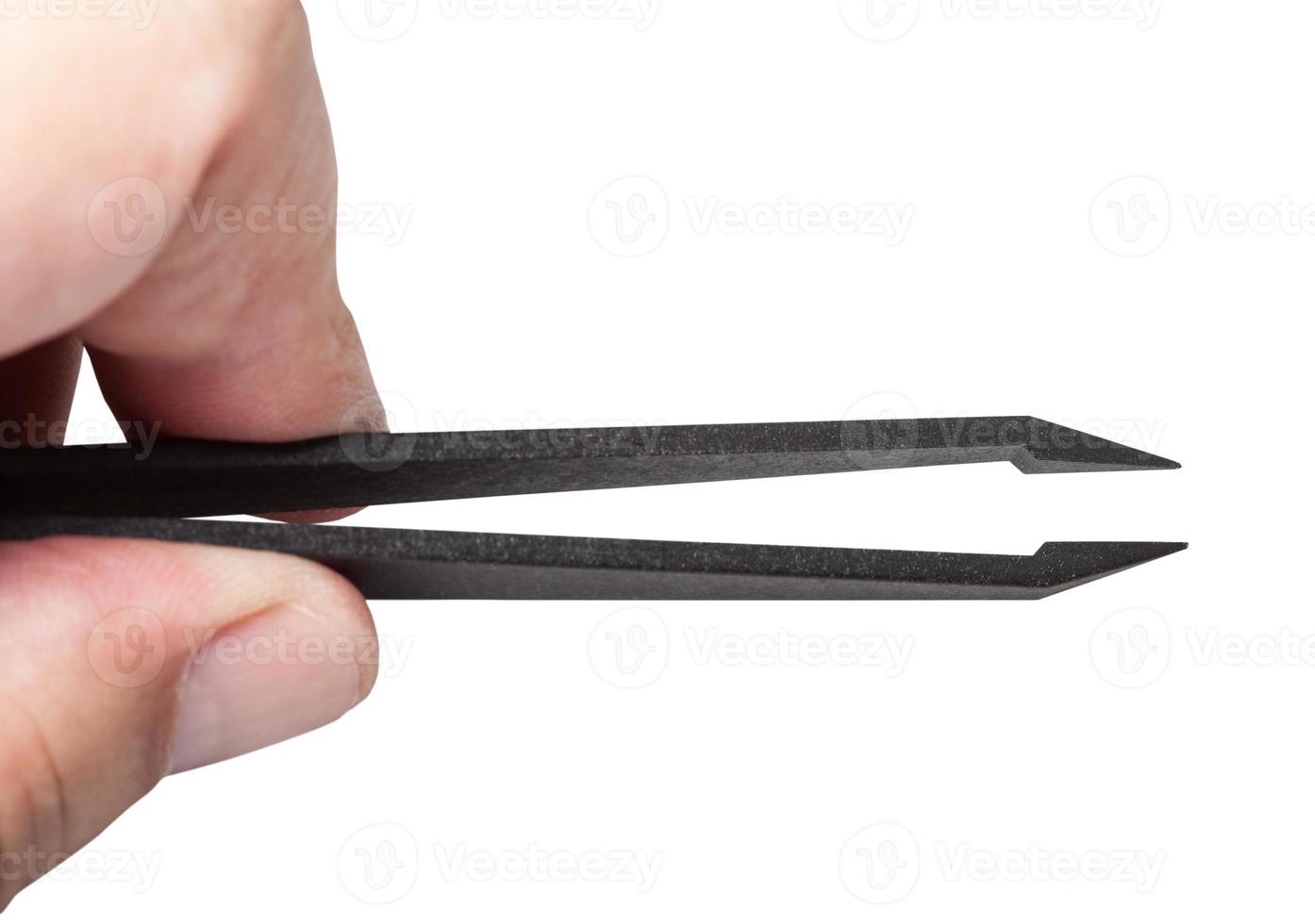 fingers hold plastic tweezers with sharp tips photo