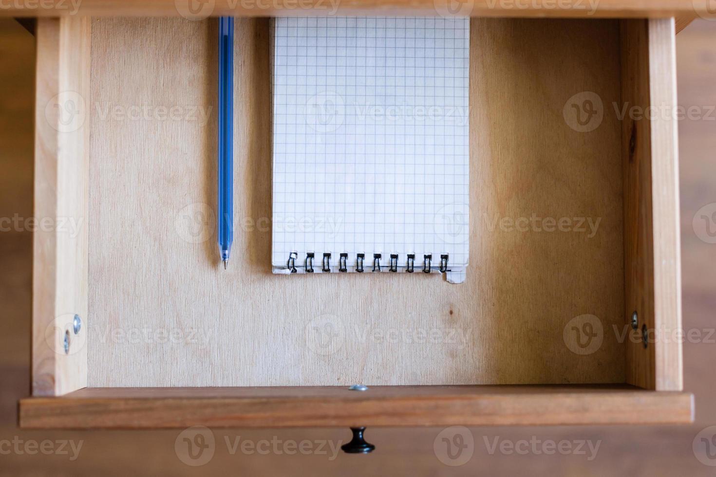 modern pen and squared notebook in open drawer photo