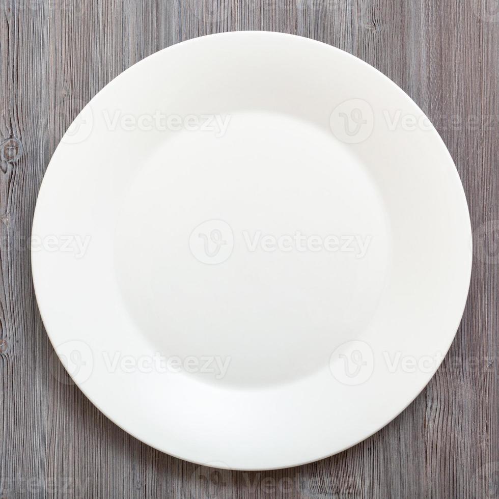 top view of white plate on gray brown table photo