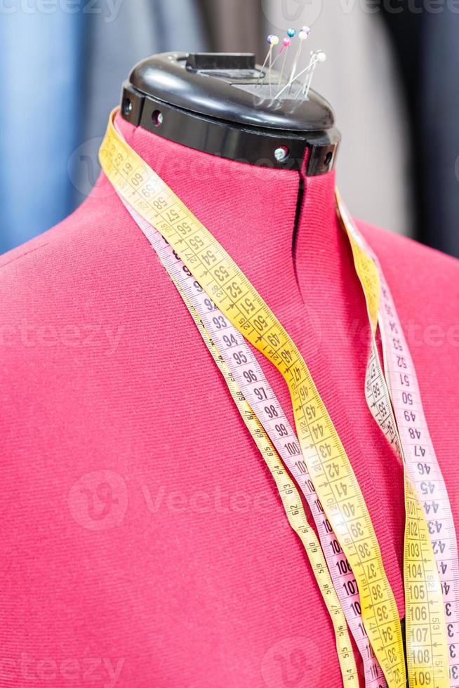 mannequin with measure tapes and ready dresses photo