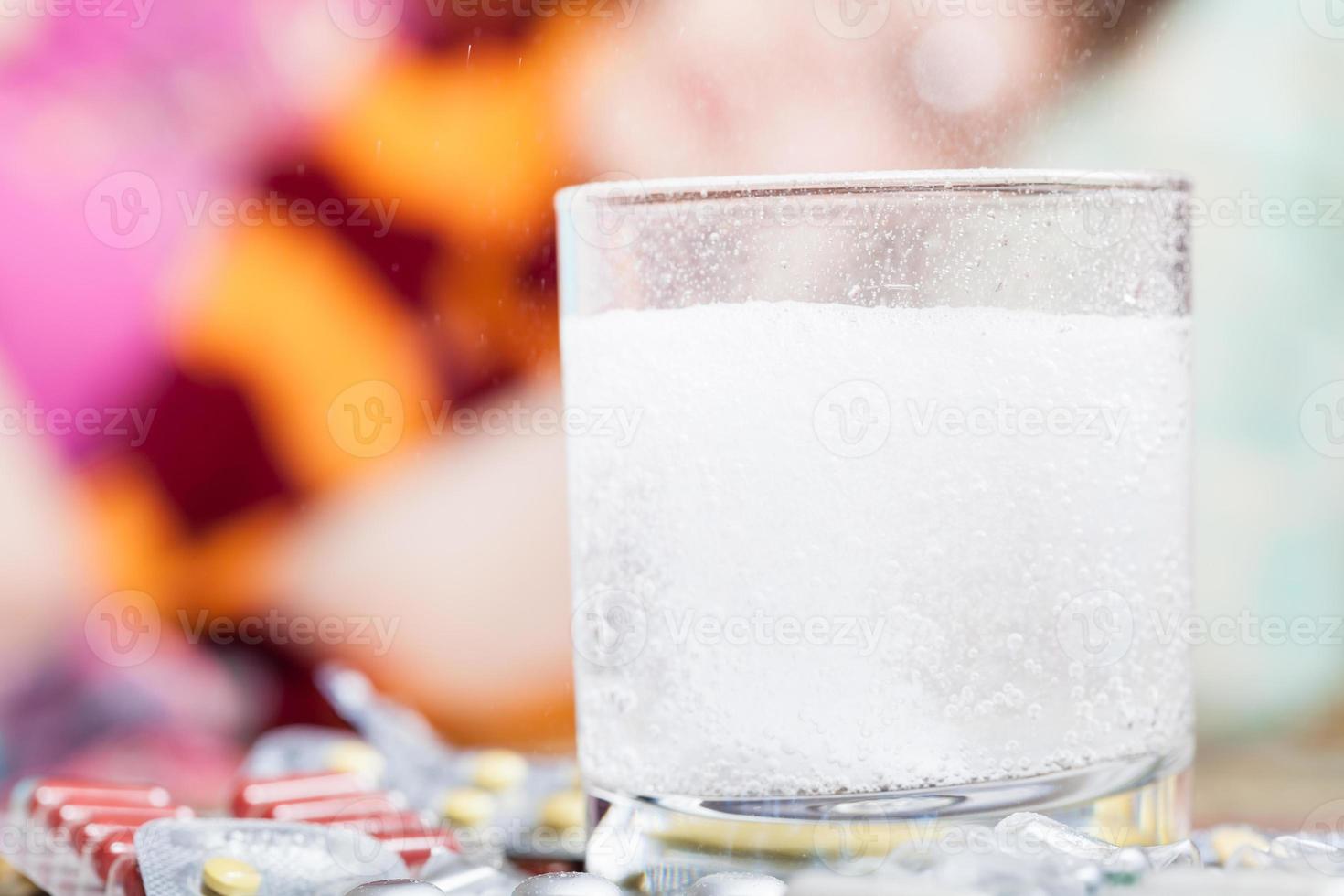 drug dissolves in glass and pill on table close up photo