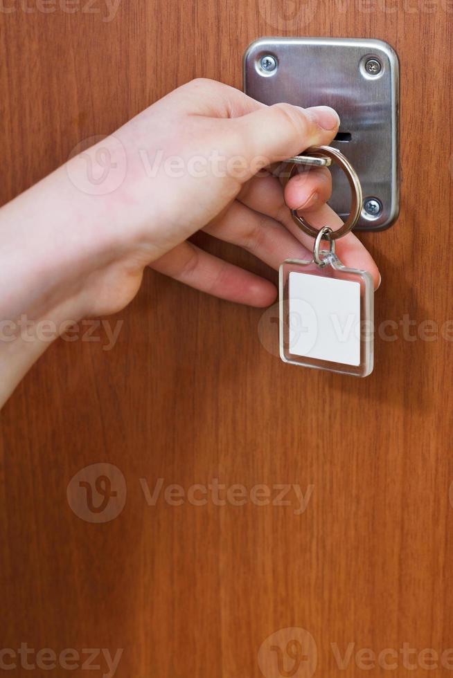 closing home door by key with blank keychain photo