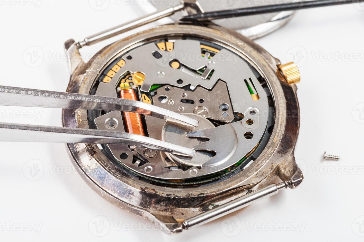 replacing battery in quartz watch by tweezers photo