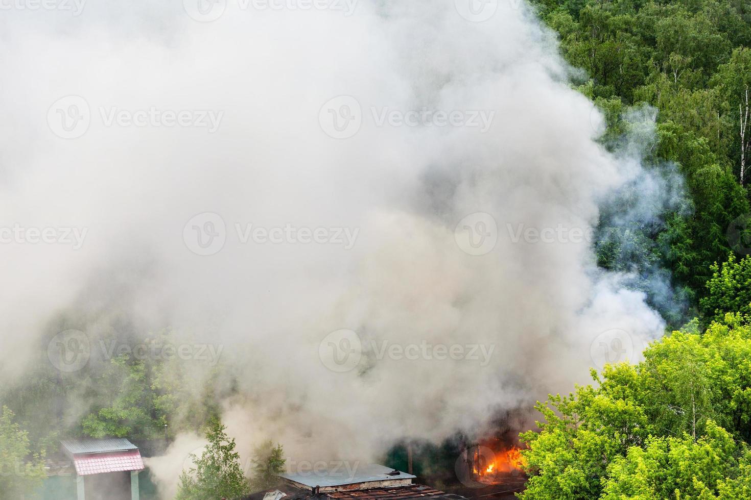 fire and gray smoke in urban parking area photo