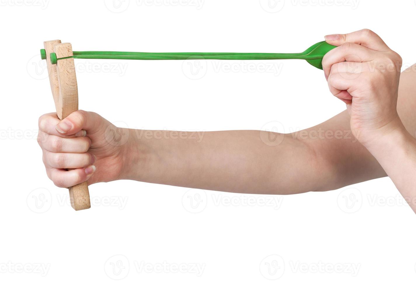 hands pulling green band of wooden slingshot photo
