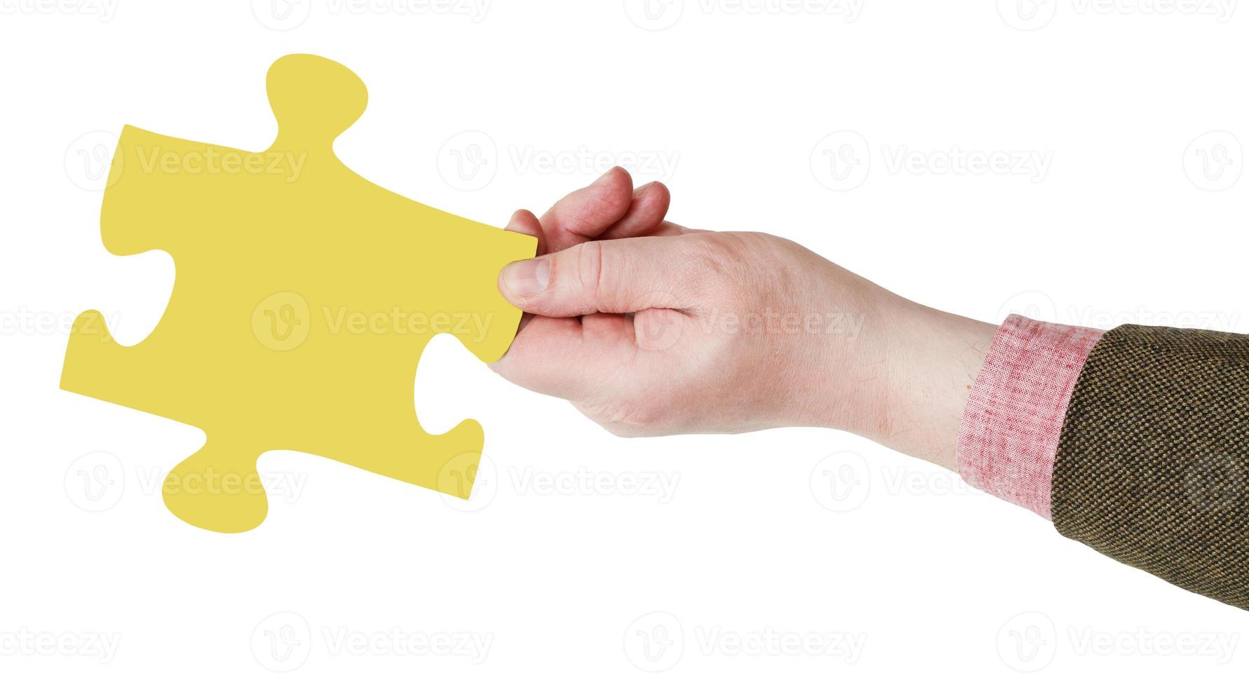 male hand with yellow puzzle piece photo