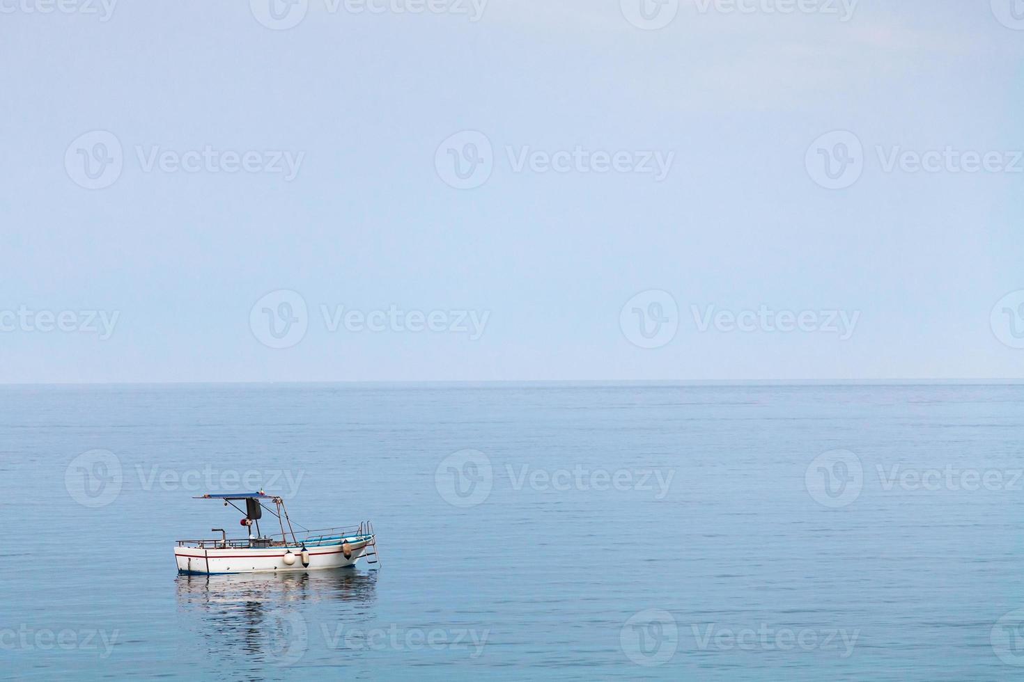 boat in Ionian sea in blue evening twilight photo