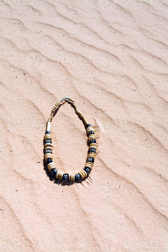 beads on red sand dune in desert photo