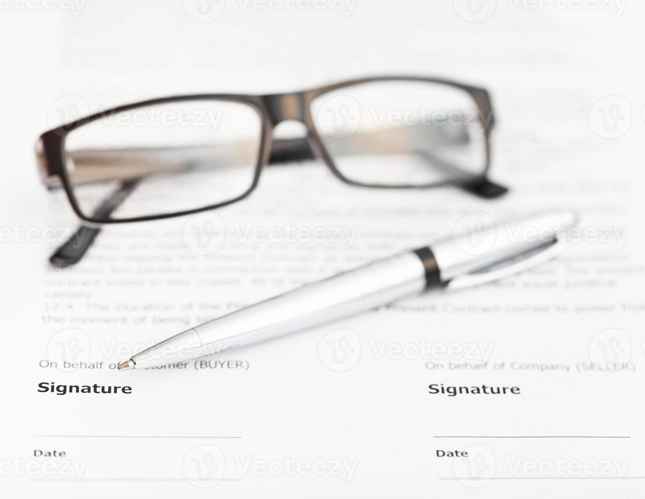 silver pen and eyeglasses on signature page photo
