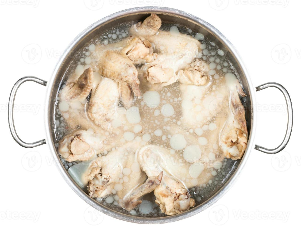 cacerola con alitas de pollo hervidas frías en caldo foto