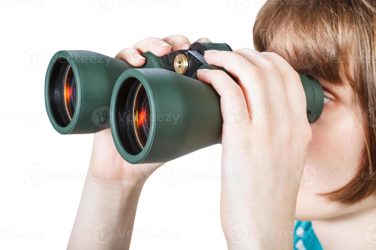 girl looks through binoculars isolated on white photo