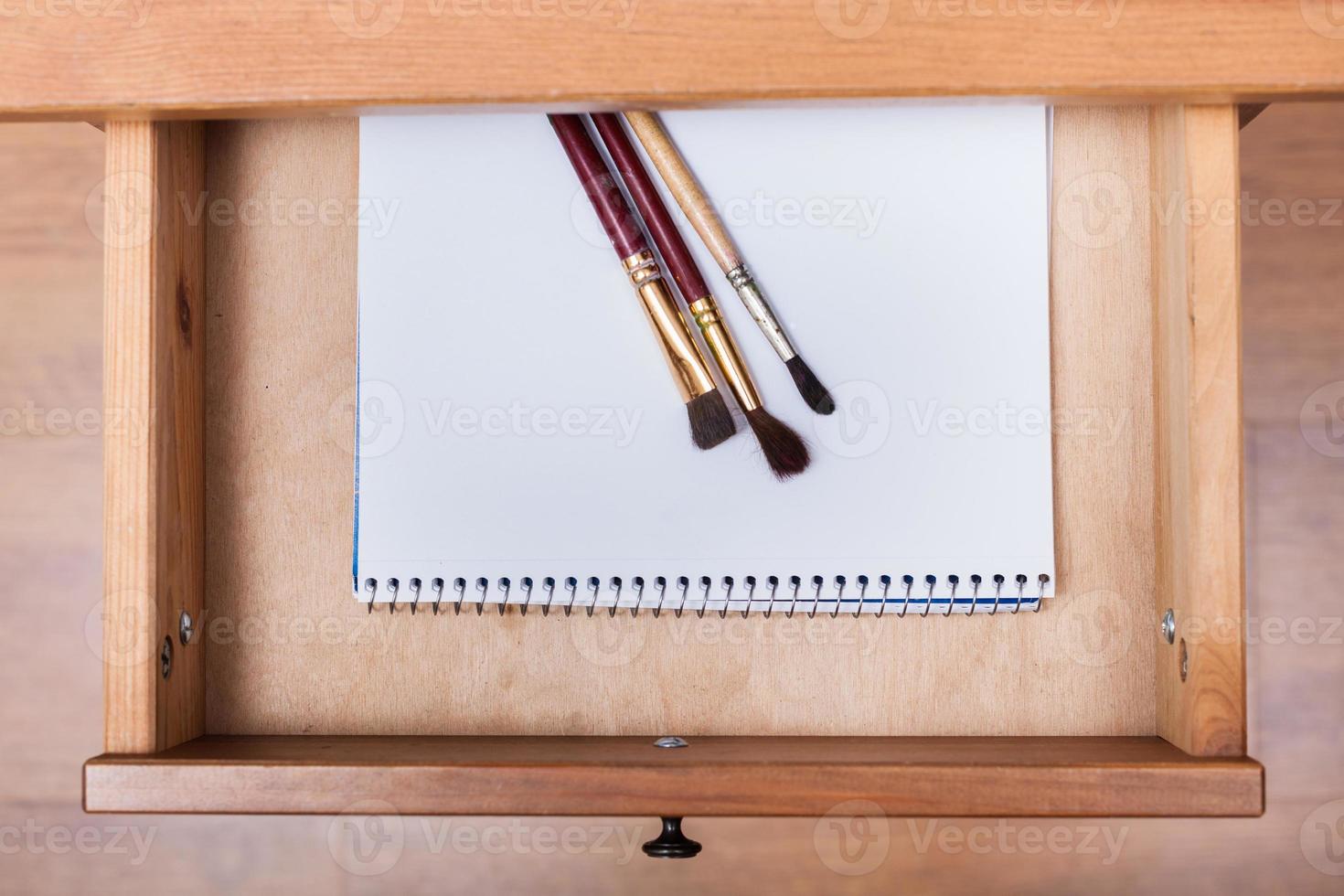 paint brushes on drawing album in open drawer photo