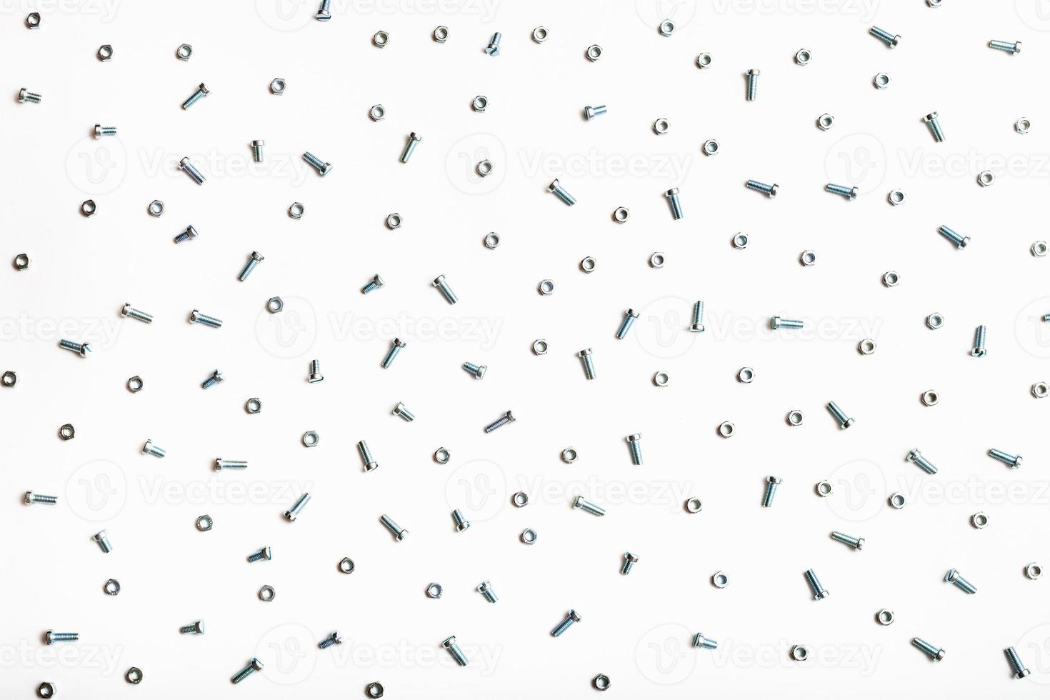 many steel bolts and nuts on white photo