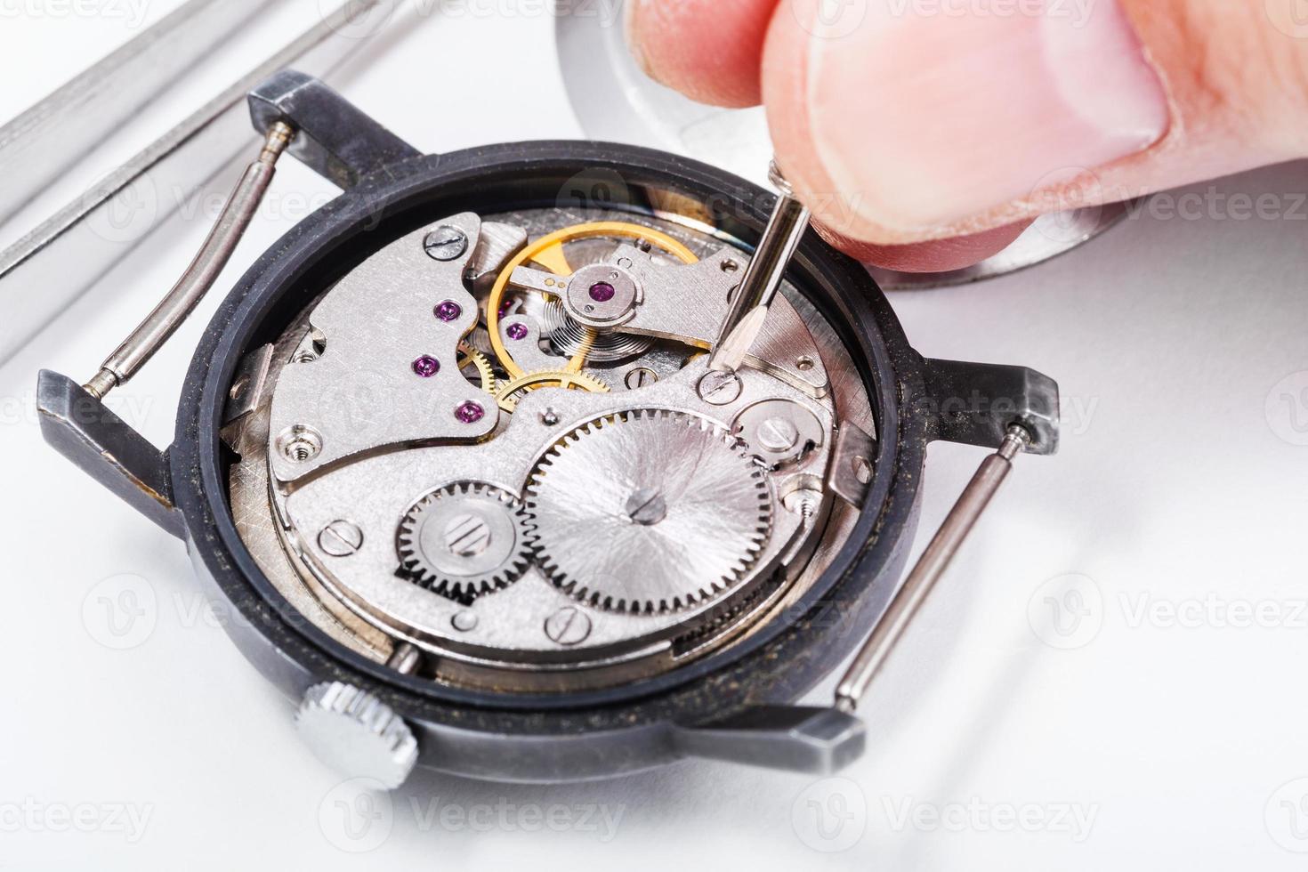 horologist repairs old watch close up photo