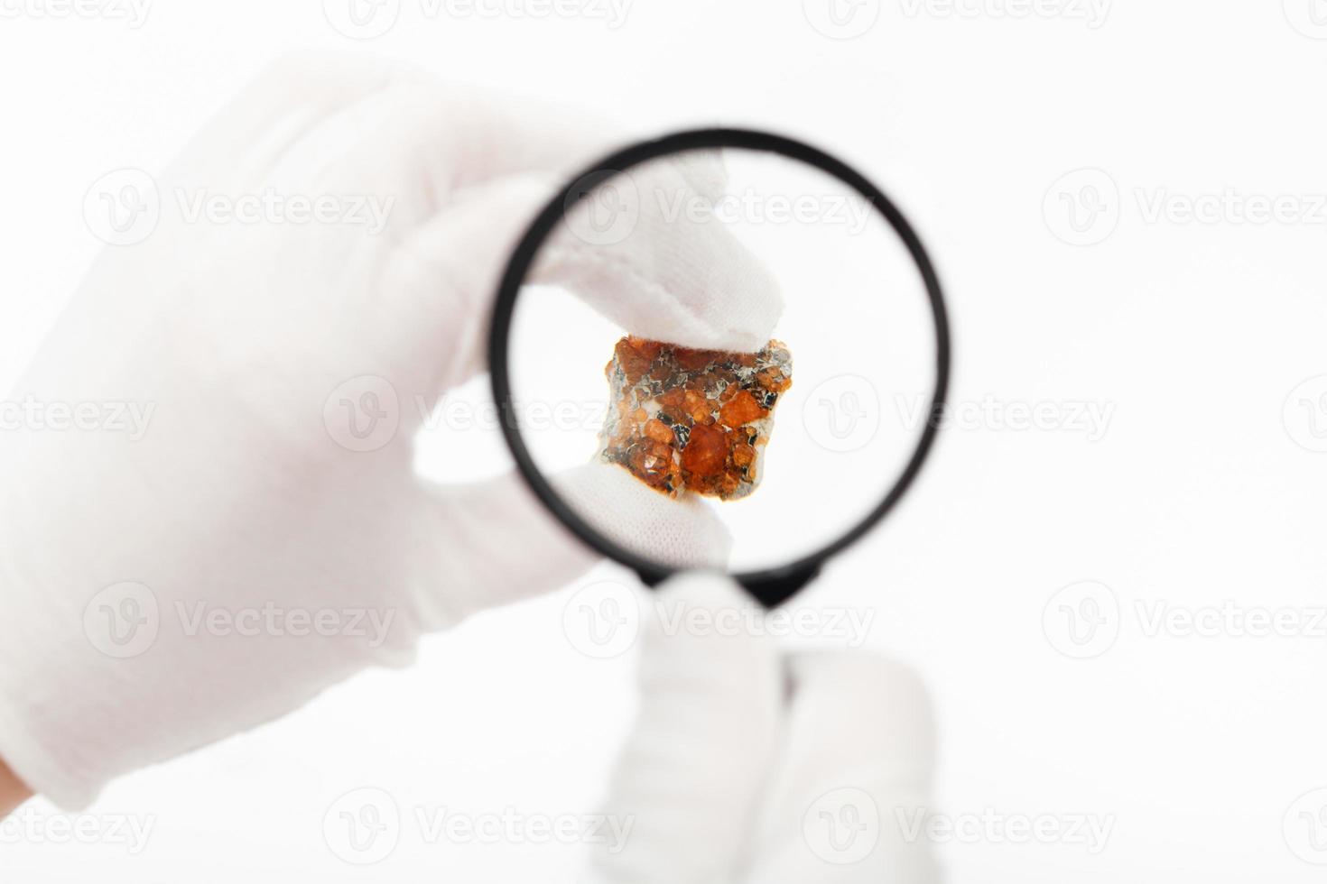 master checks spessartine garnets with magnifier photo