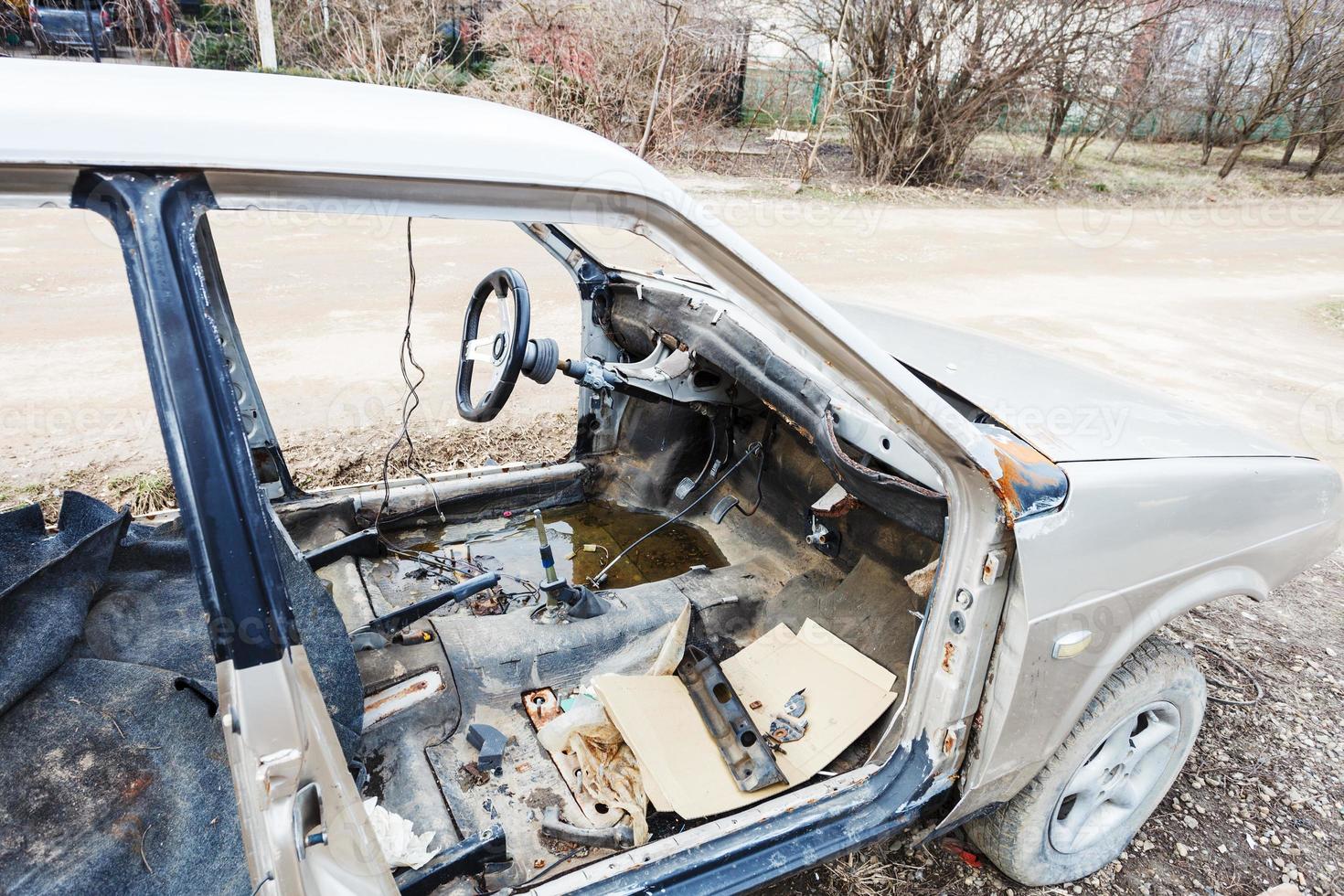 old disassembled car on country road photo