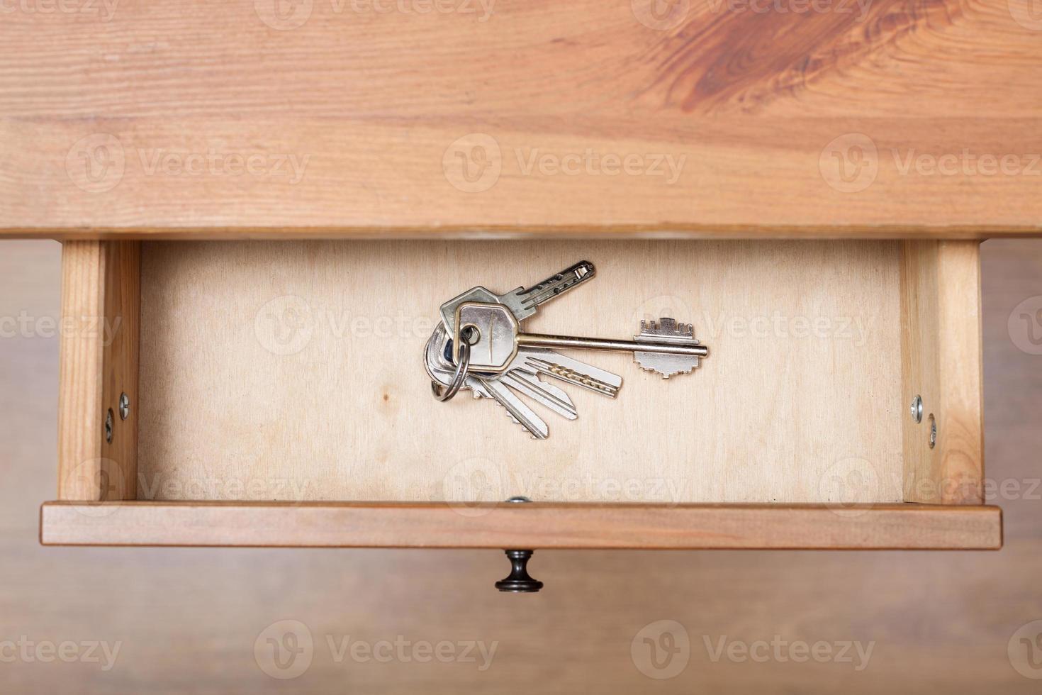 bunch of door keys on ring in open drawer photo