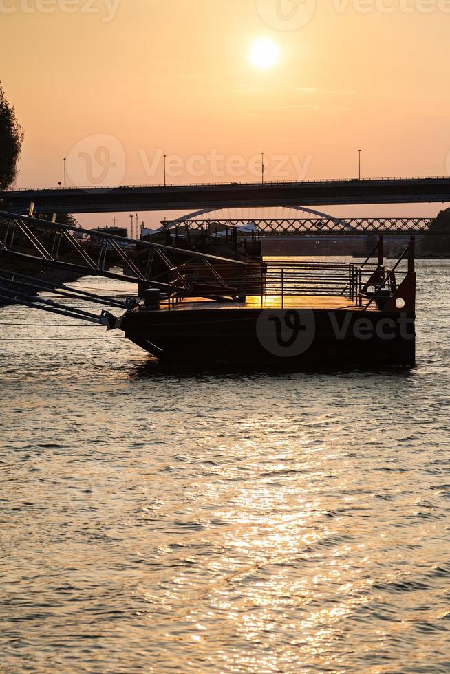 jetty on Danube river at yellow dawn photo