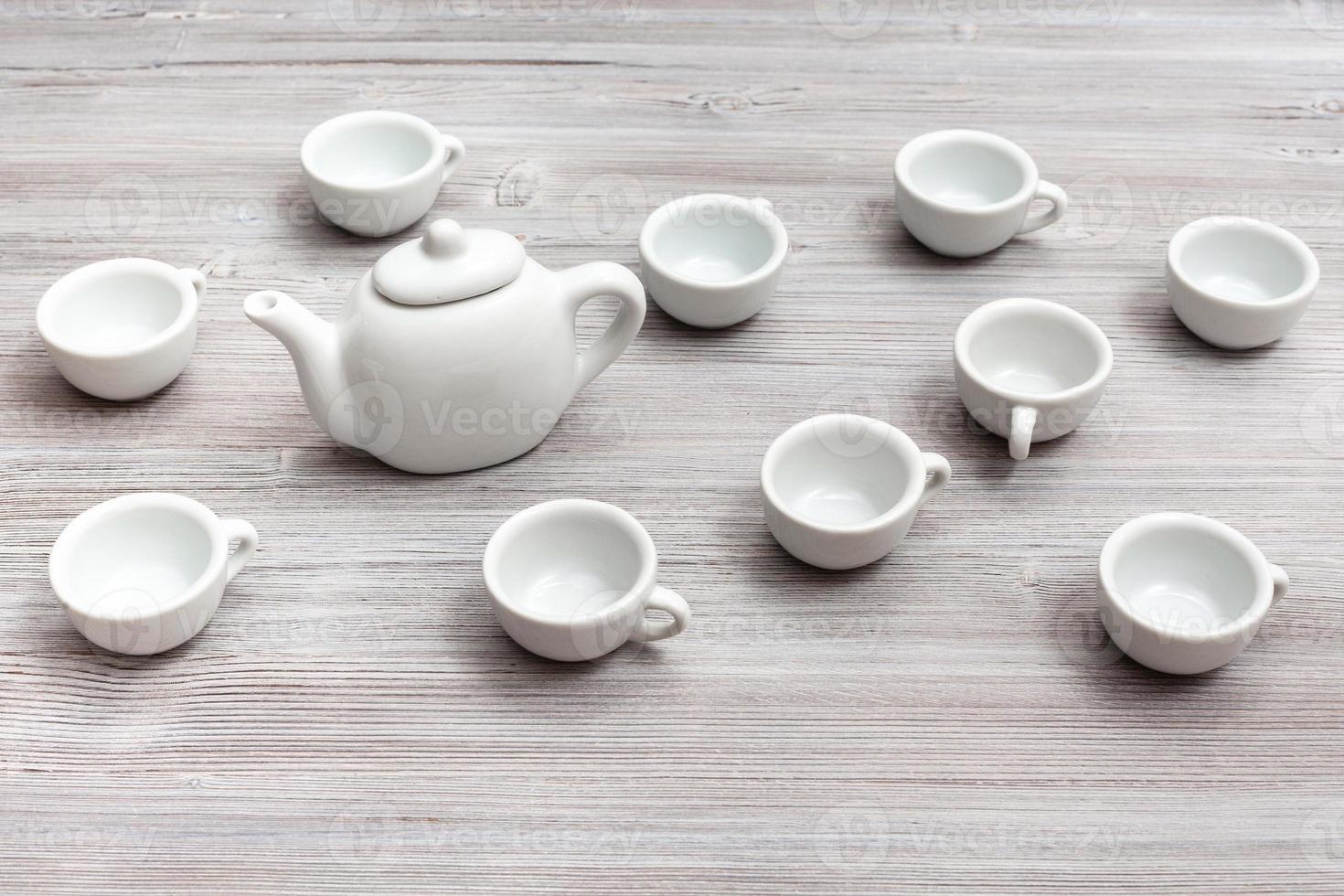 white ceramic cups and teapot on gray brown table photo