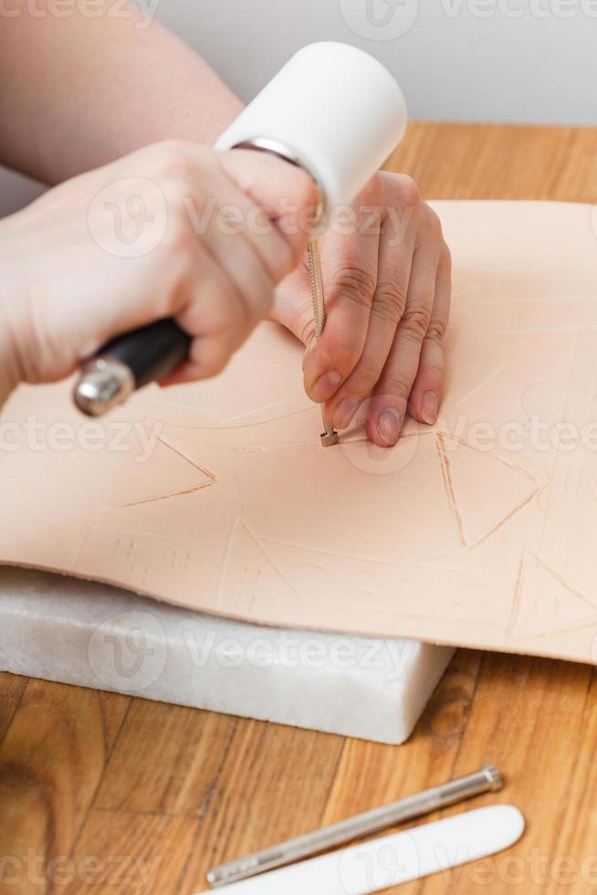 craftsman puts embossing on leather photo