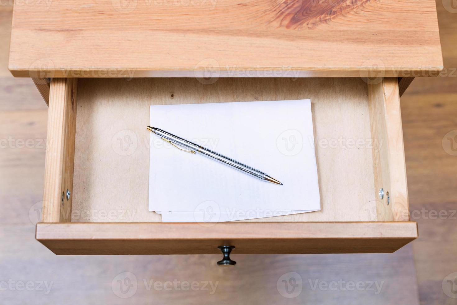 folded note and pen in open drawer photo