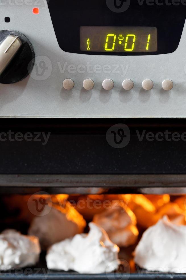 cooking of sweet dessert meringue in oven photo