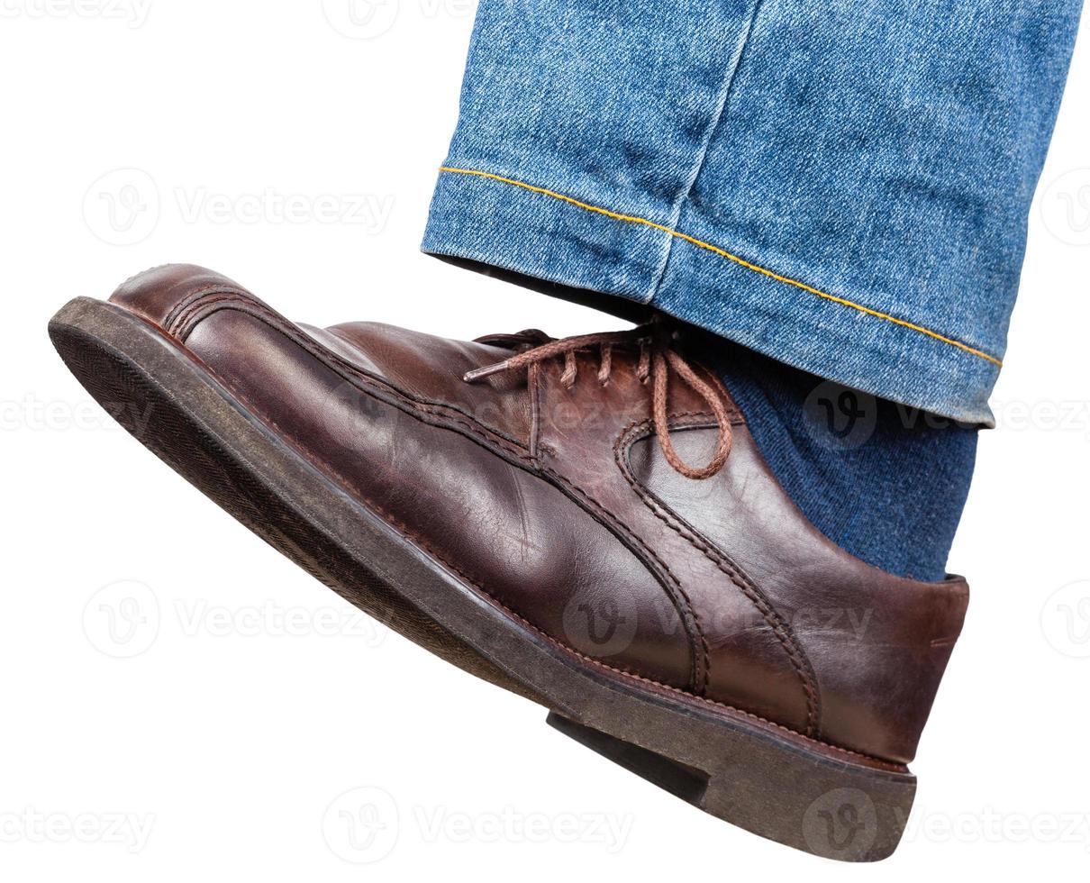 pierna izquierda en jeans y zapatos marrones da un paso foto