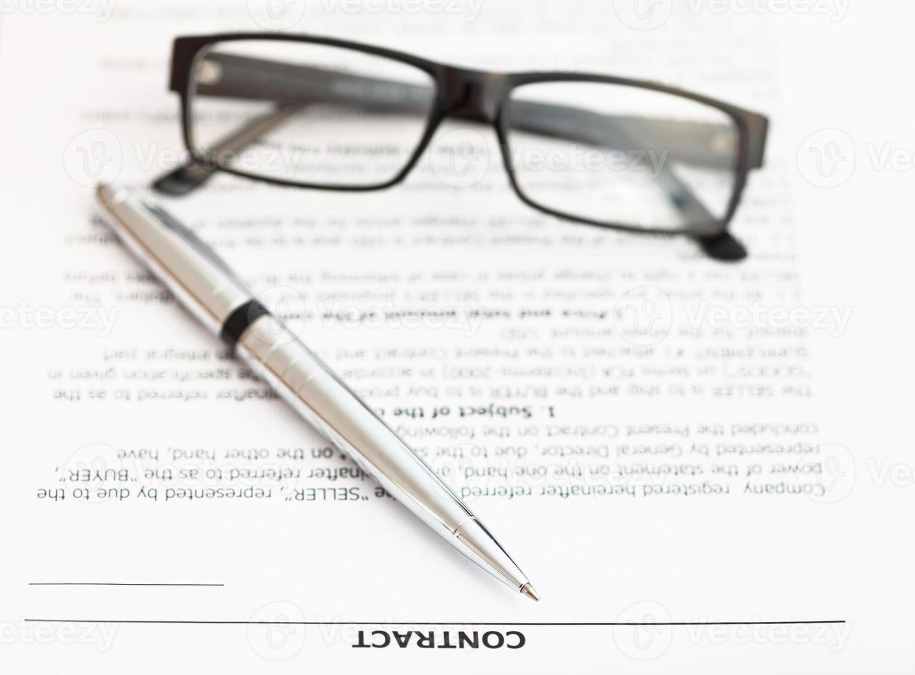 silver pen and eyeglasses on sales contract photo