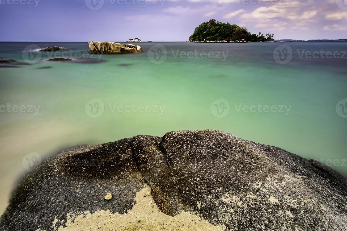 Sandy coastline with big stone photo