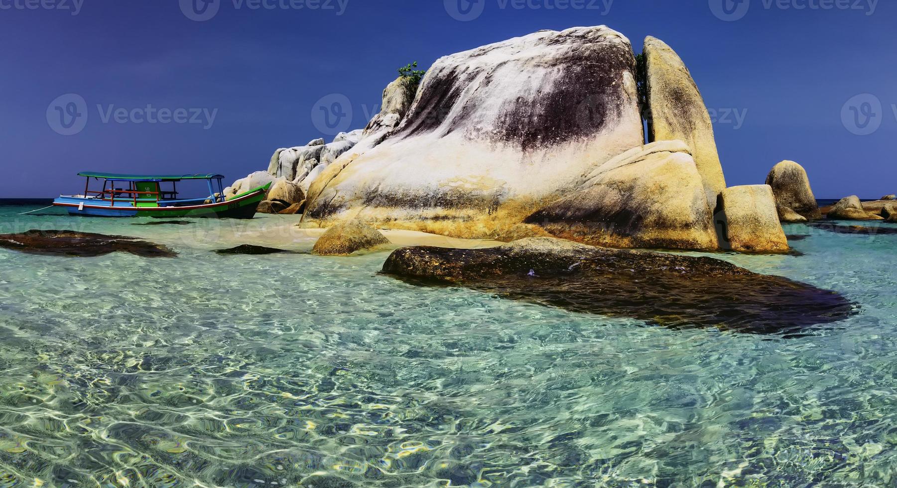 Large stones with a tourist boat photo