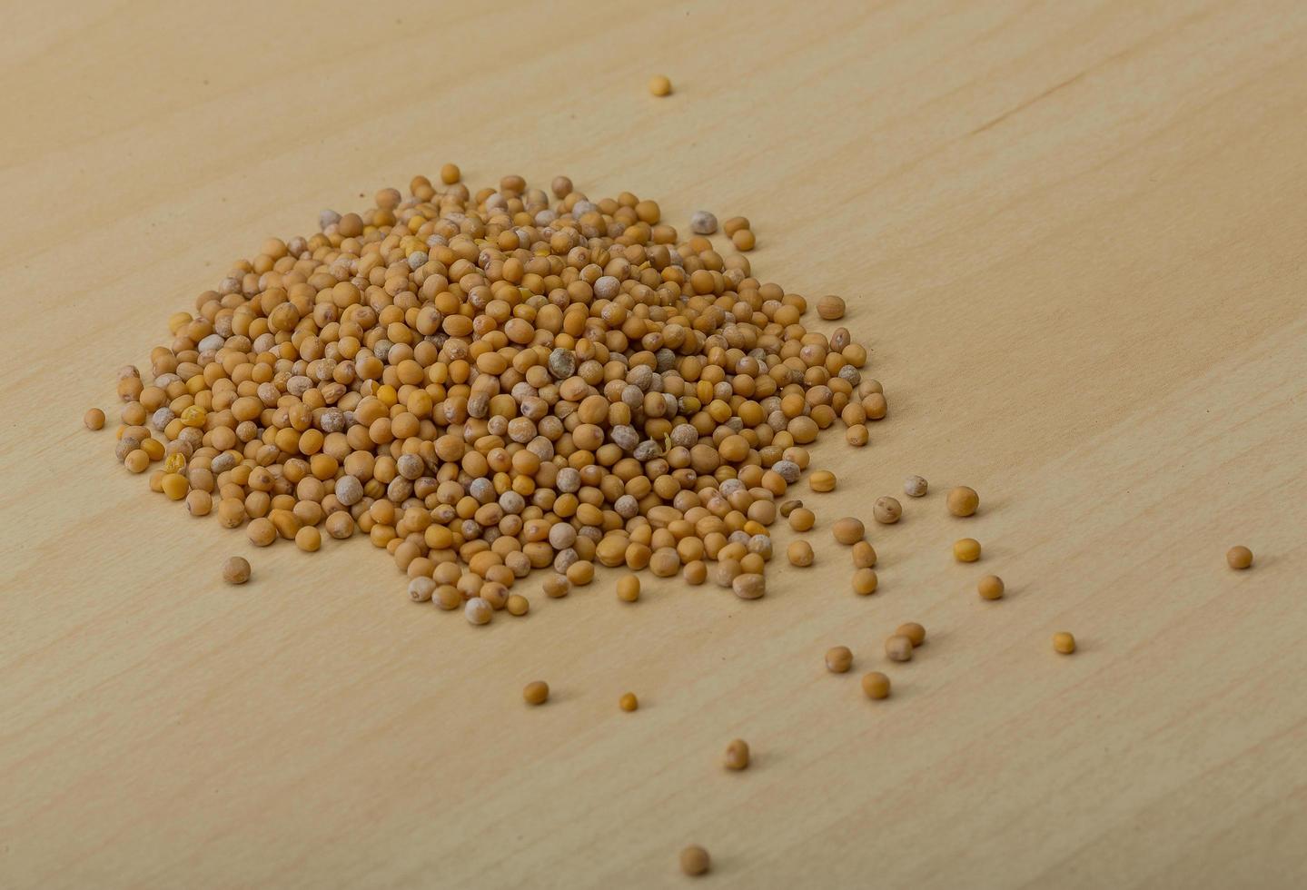 Mustard seeds on wooden background photo