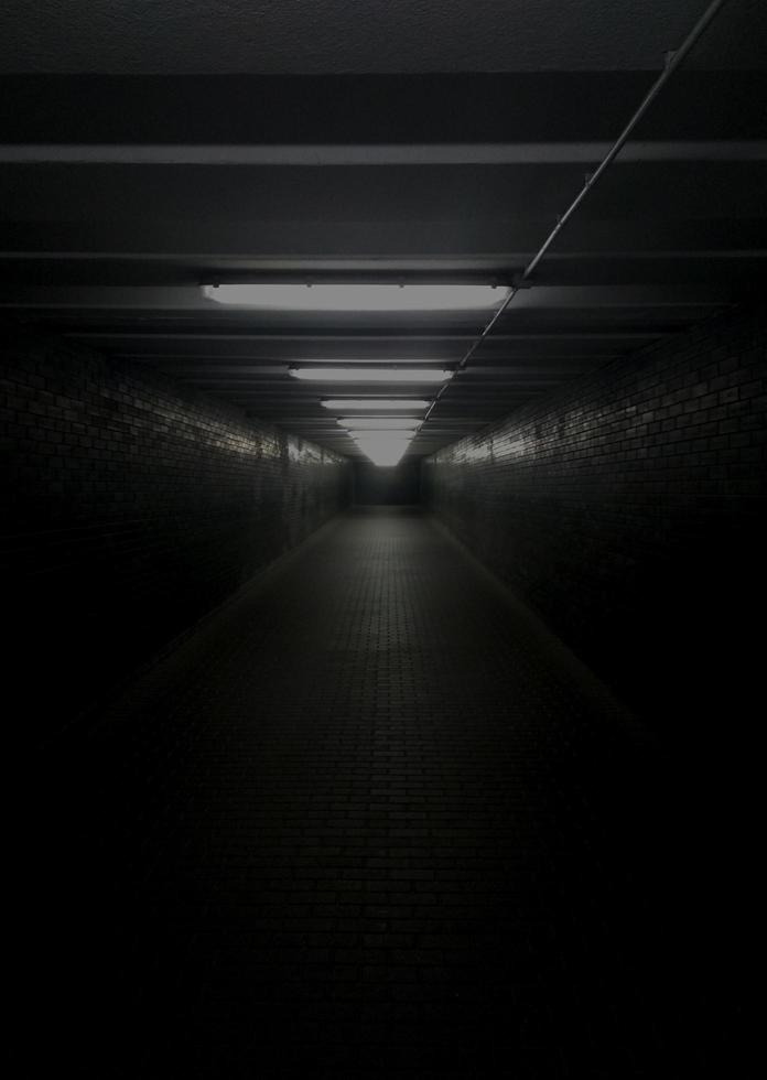 Dark scary tunnel. Underground passage with dim light photo