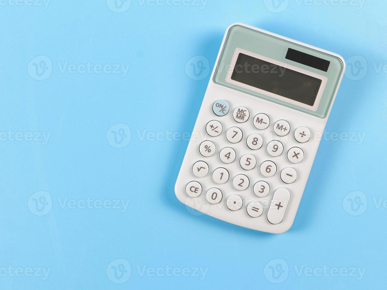 flat lay of blue calculator on blue background with copy space. photo