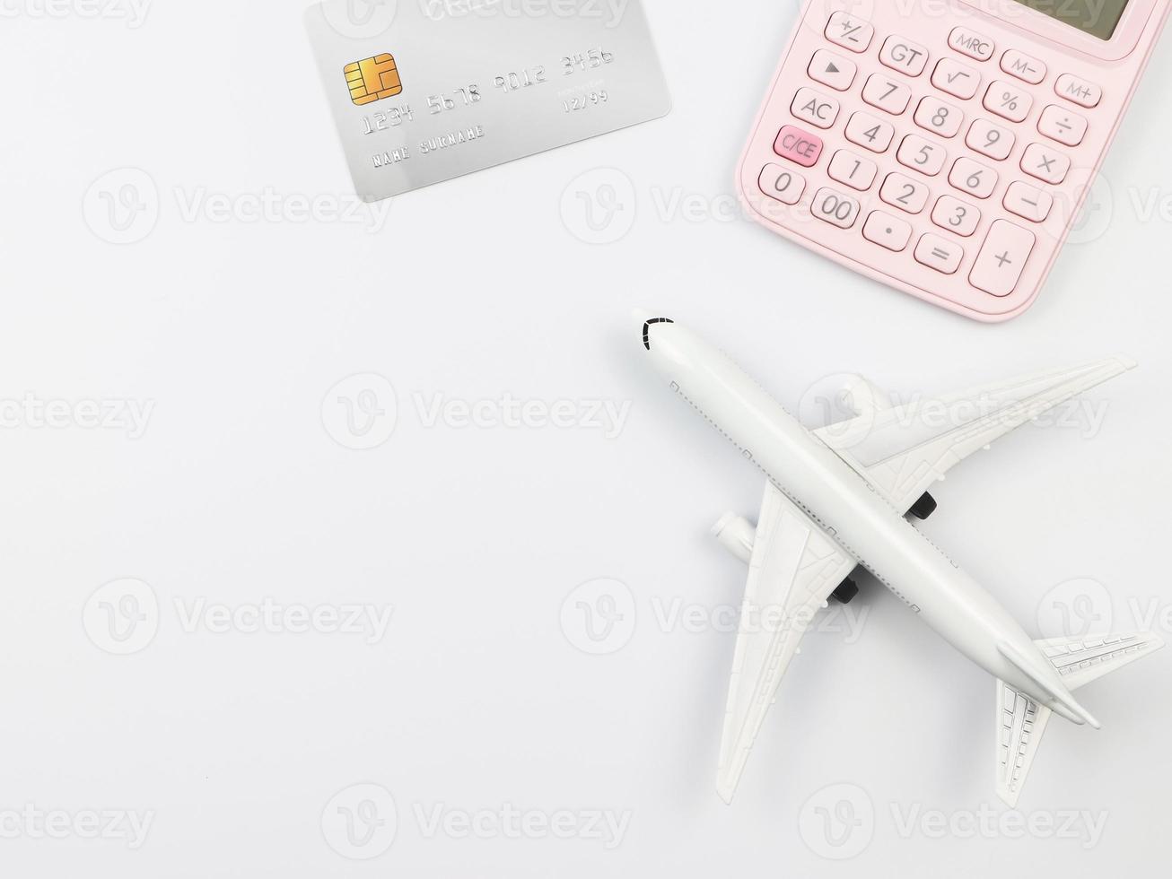 flat lay of airplane model, pink calculator and credit card,  preparation for traveling concept. photo