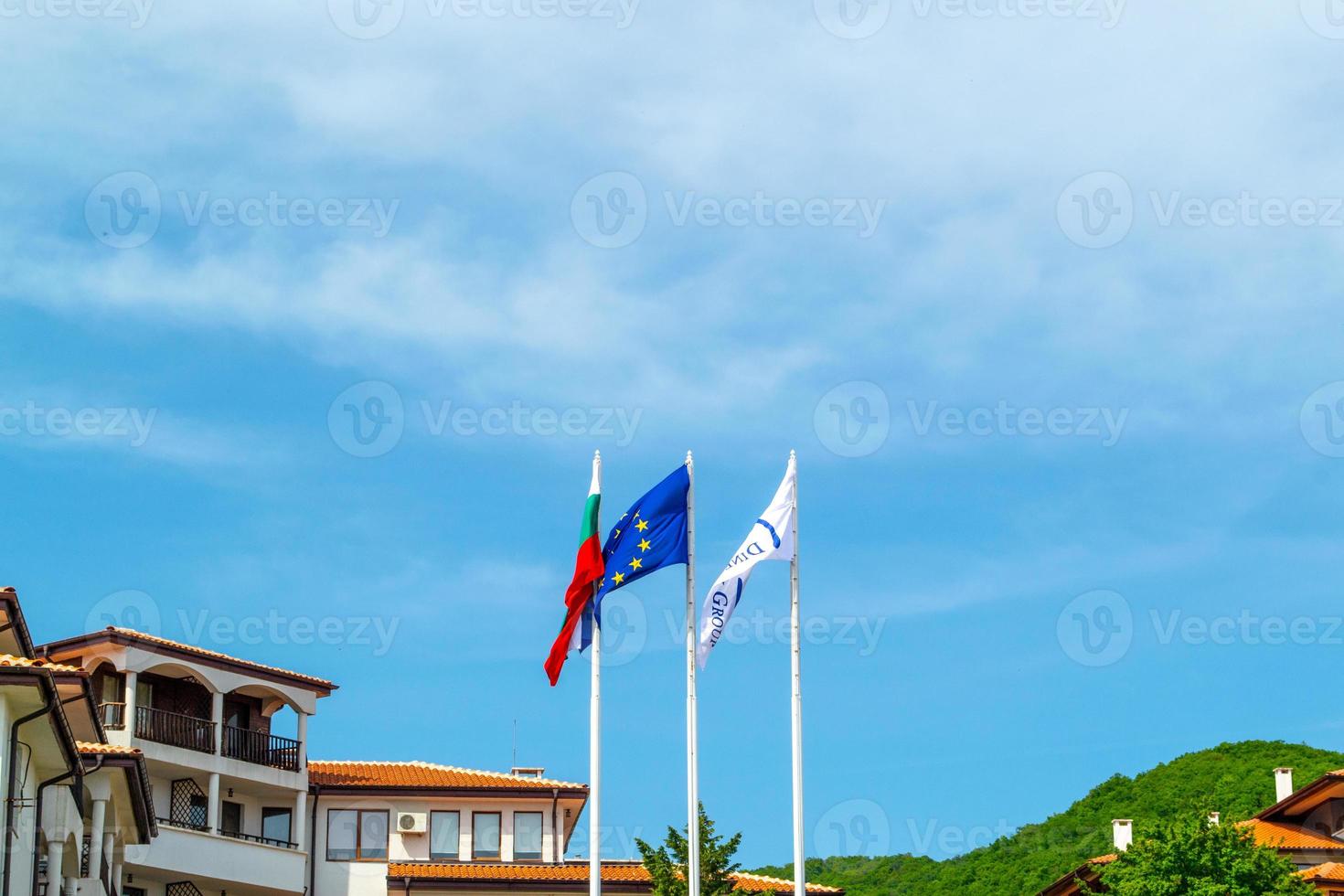 Flag of Bulgaria and European Union waving with the wind above villas photo