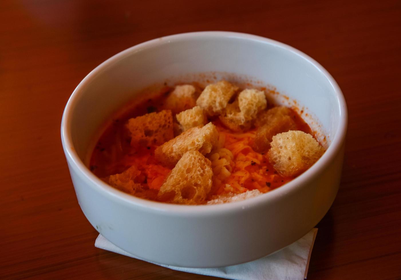 Tomato soup on wooden background photo